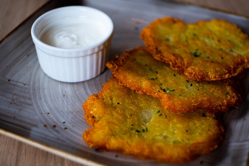 a plate of Belarus potato pancakes with sour cream