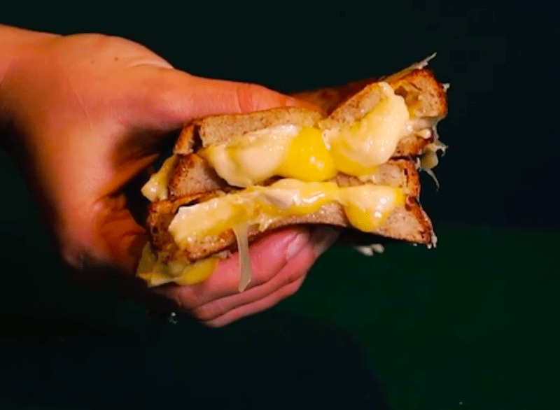 A picture of someone holding a grilled cheese toastie