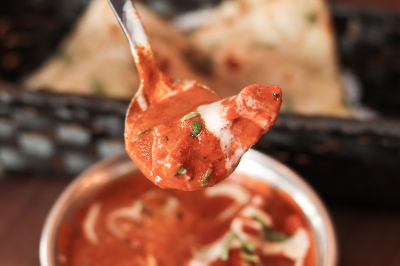 A spoon of butter chicken 