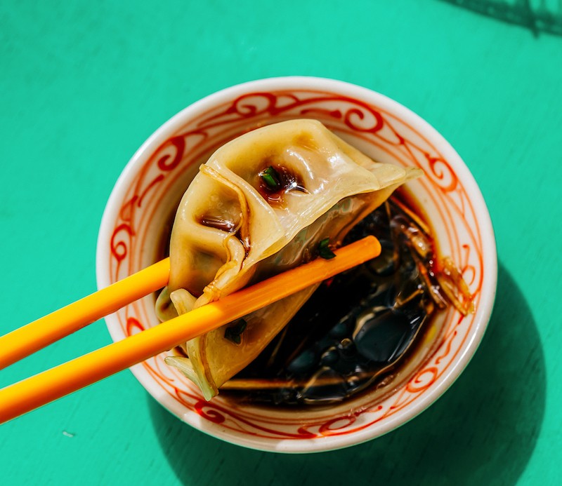 Picture of KARANA's plant based dumplings dipped in soy sauce