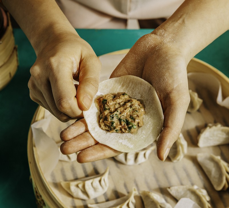 Picture of a person folding dumplings
