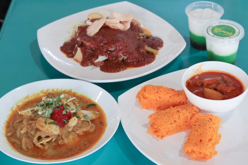 A table with three dishes from Lemaq including laksa, roti kirai and ga-do ga-do