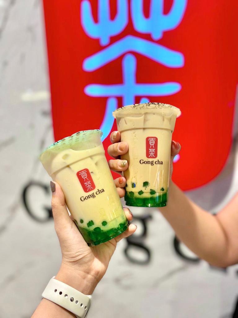 A pair of milk tea cups with pandan pearls
