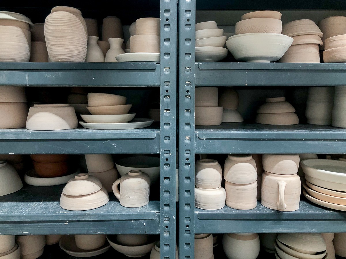A shelf filled with unfinished pottery products made during the craft workshop