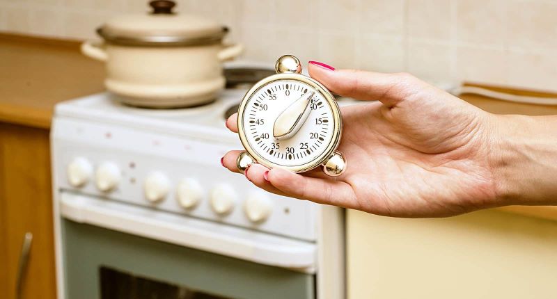 Woman holding up a kitchen timer