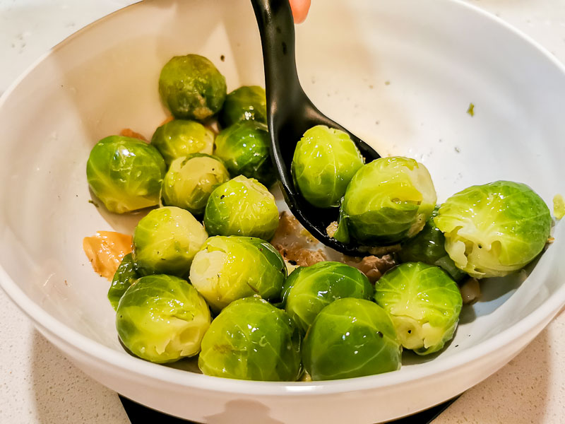 Tossing brussel sprouts in olive oil and seasoning