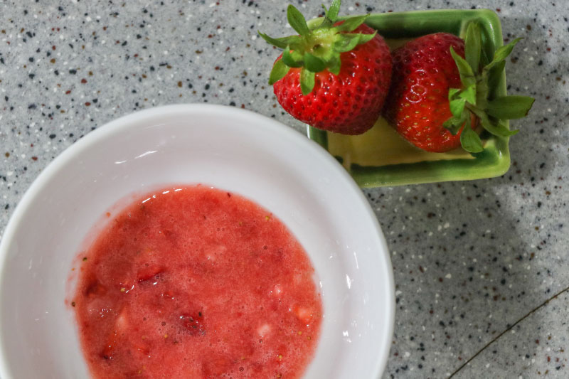 a flatlay of strawberry puree and strawberries