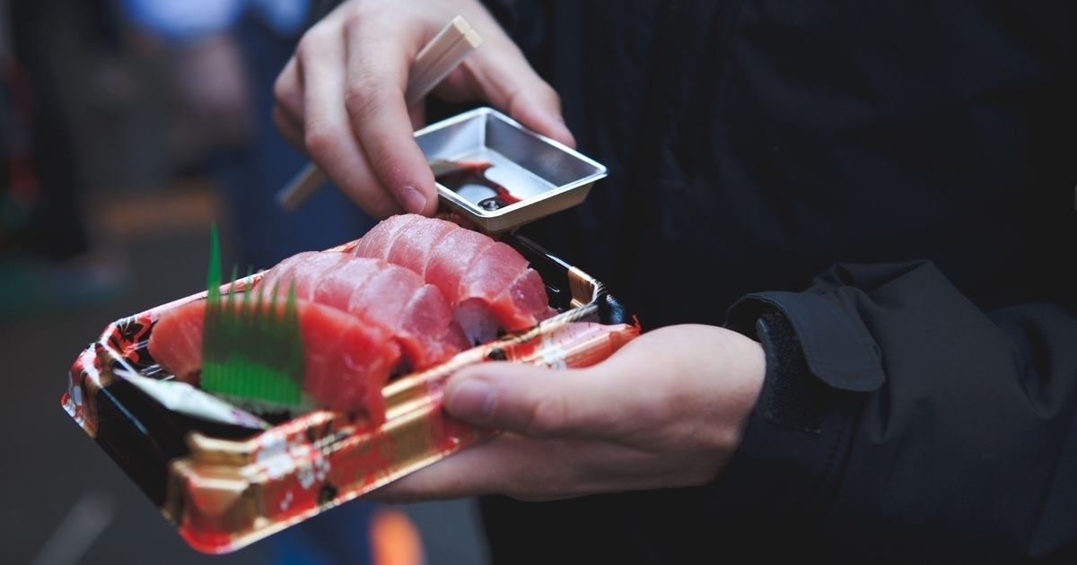 A man holding tuna sushi