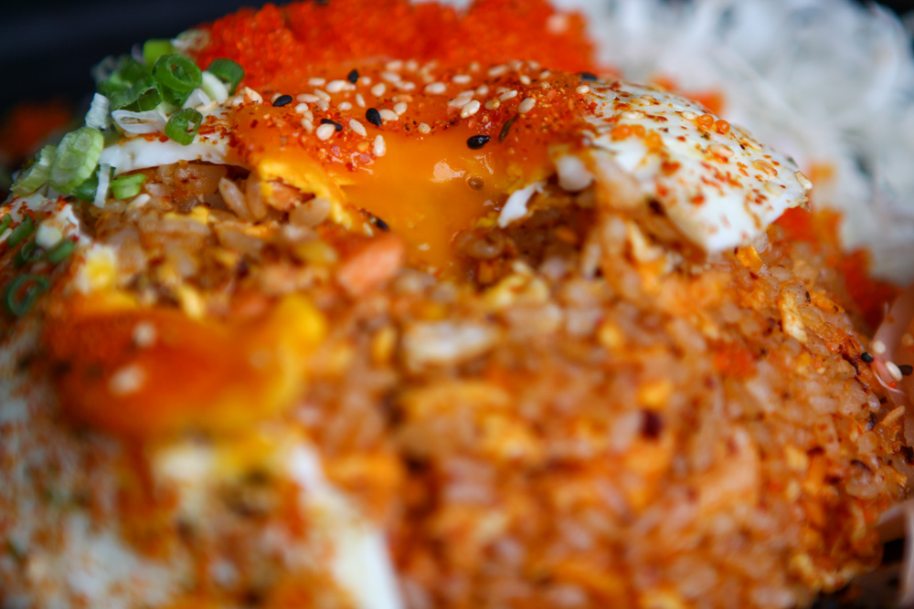 Close up of broken runny egg yolk in mala fried rice