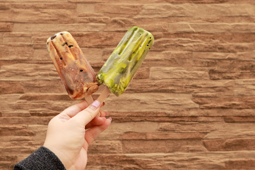 holding 2 ice-cream sticks