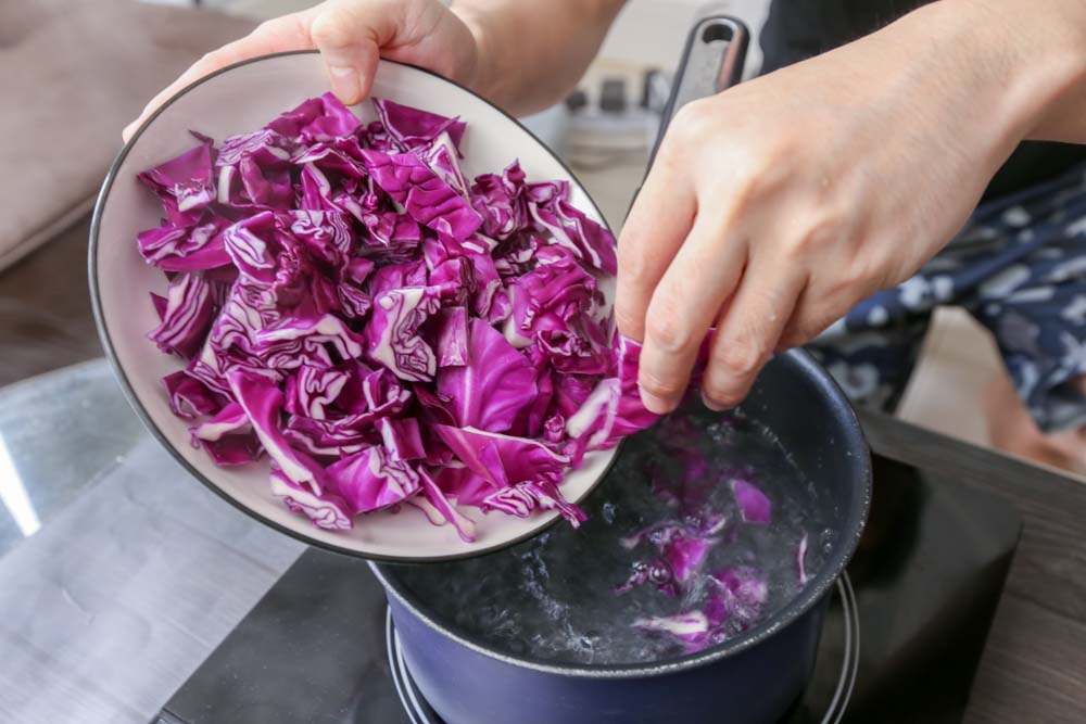 Photo of placing red cabbage into boiling water