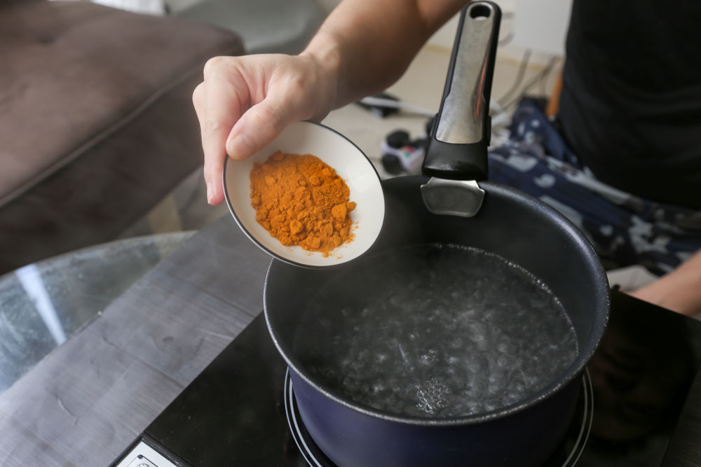 Photo of adding turmeric powder into boiling water