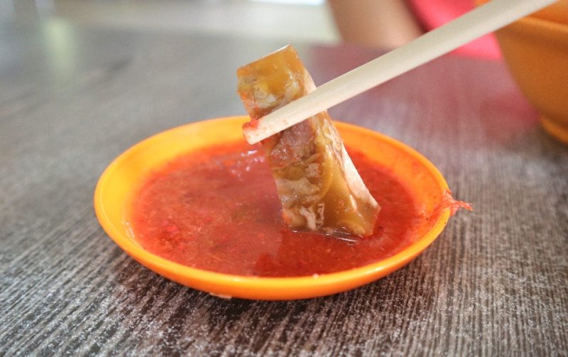 lao liang pork trotter jelly & shark meat - dipping in chilli closeup