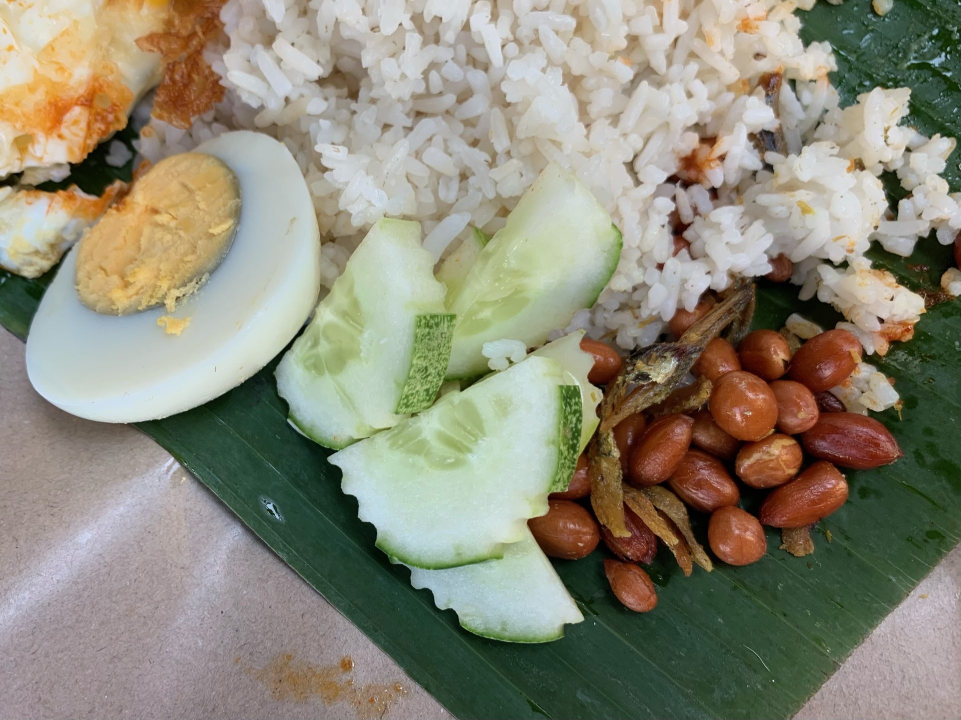 Nasi Lemak Alor Corner - Half boiled egg, cucumber, fried peanuts, and fried anchovies