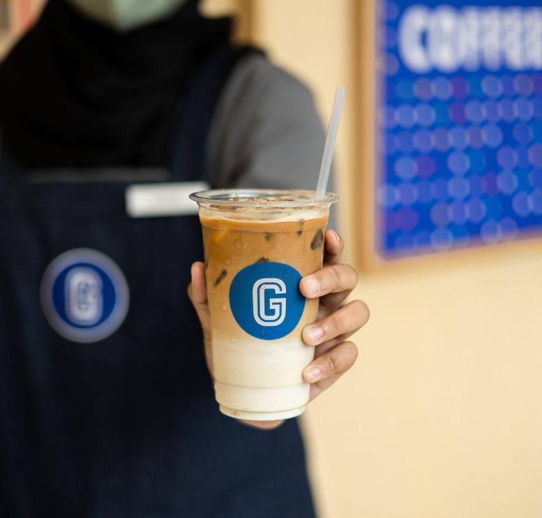 Gigi Coffee - Someone holding an iced latte