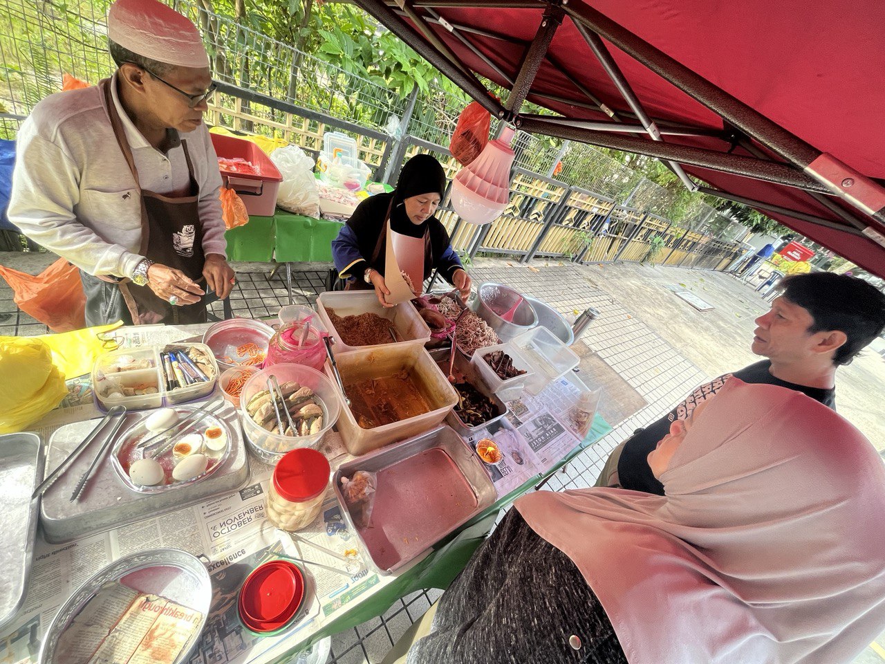 photo 6149985528687211849 y Nasi Kerabu Mek - makcik serving dishes