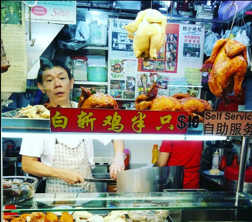 Leong Yeow - Chicken rice storefront with man chopping chicken Leong Yeow - Chicken rice storefront with man chopping chicken