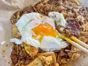 hai yan fried kway teow mee - char kway teow, close up on egg yolk