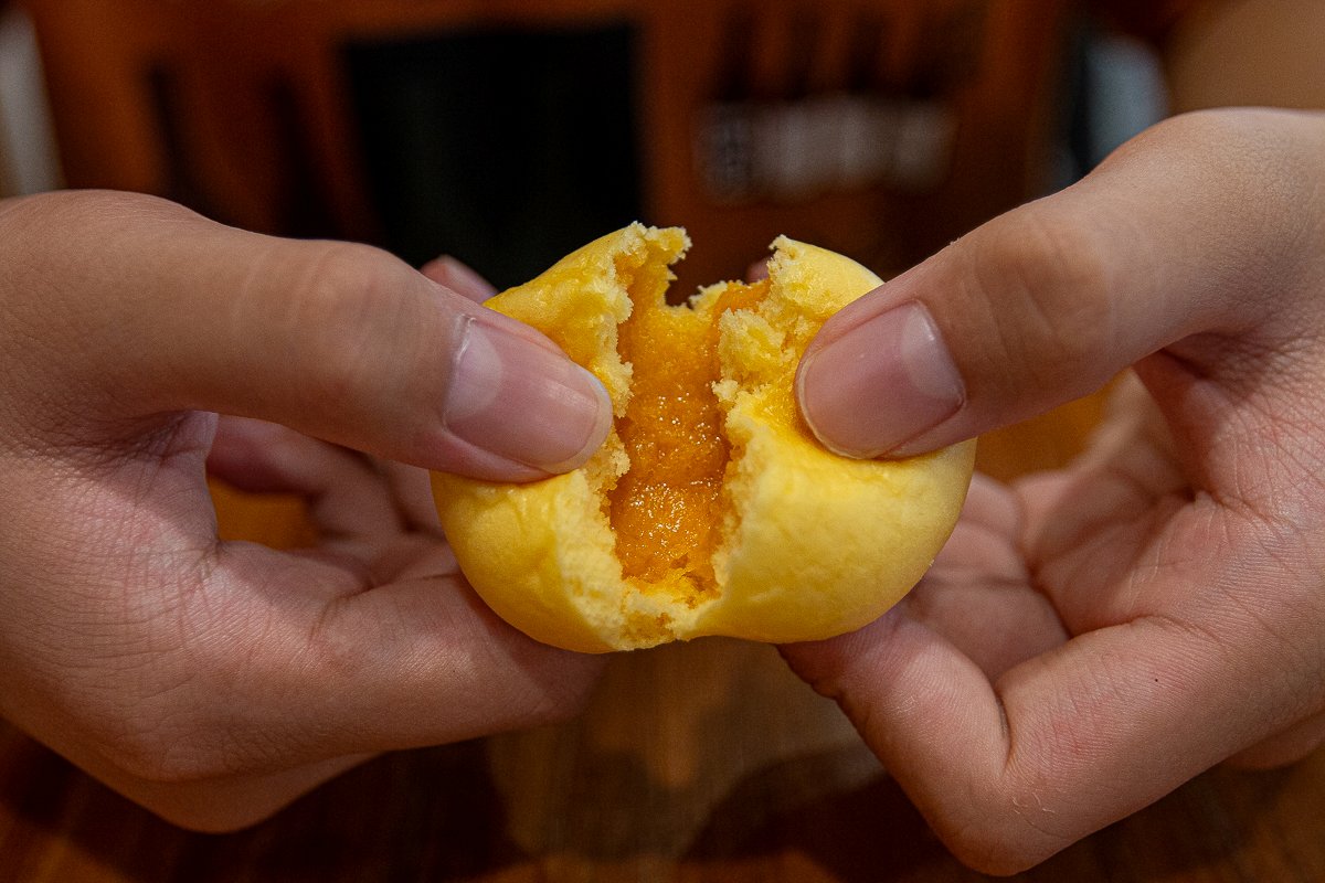 Warung Dimsum - salted egg pau torn open Warung Dimsum - salted egg pau torn open
