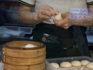 zhujiao dumpling - worker rolling the xiao long baos
