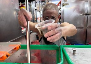 sun kee drinks - uncle pouring grass jelly drink