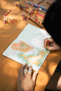 Artist sketching cats on a notebook