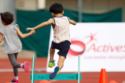 shot of a child jumping over a hurdle