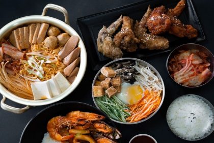 table of korean army stew, korean fried chicken and seafood stew with rice